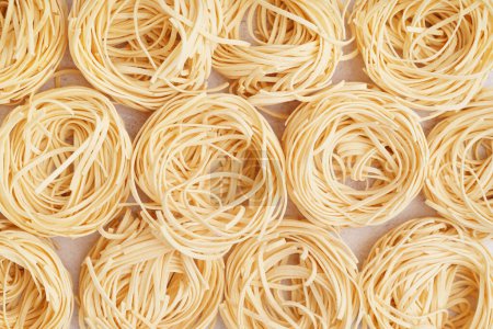 Uncooked capellini pasta on light background
