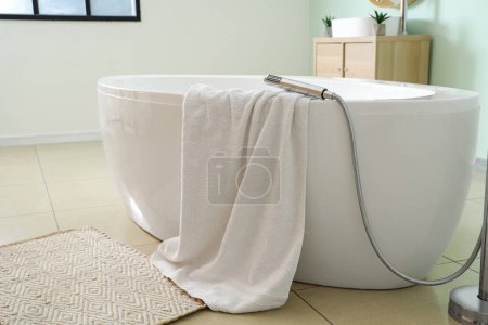 Bathtub with towel in bathroom