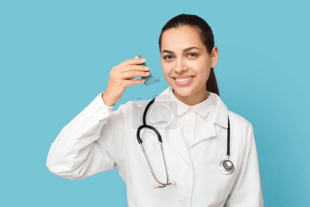 Porträt einer Ärztin mit Inhalator auf blauem Hintergrund