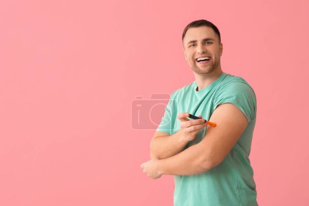 Schöner junger glücklicher Diabetiker mit Spitzstiften auf rosa Hintergrund