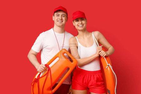 Rettungsschwimmer mit Ringboje und Rettungsschlauch auf rotem Hintergrund