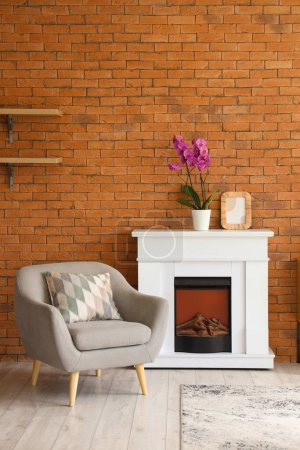 Interior of living room with armchair and orchid flower on fireplace