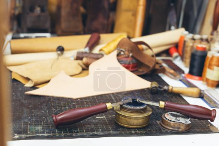 Photo for Tools and leather at cobbler workplace. Set of leather craft tools on background. - Royalty Free Image