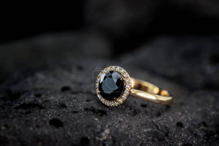Foto de Anillo de oro con diamante negro sobre piedra - Imagen libre de derechos