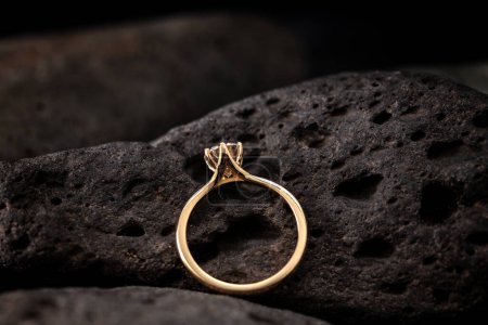 Photo for Yellow gold ring with diamond on black coal - Royalty Free Image
