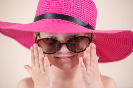 retrato de mujer joven en sombrero de verano con gafas de sol rosadas