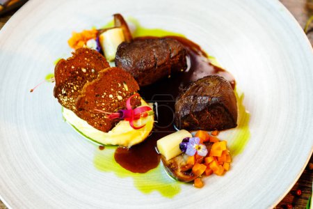 Photo for Deer tenderloin. Truffle-potato puree, porcini mushrooms, baked leek and carrot, juniper bread, port wine sauce. Delicious healthy traditional food served for lunch in modern gourmet restaurant. - Royalty Free Image