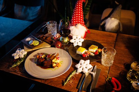 Photo for Deer tenderloin and dessert. Christmas table served for eve celebration event. Delicious healthy traditional food served for lunch in modern gourmet restaurant. - Royalty Free Image