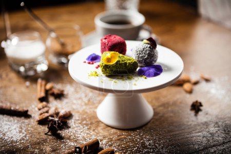 Photo for Vegan truffles dessert made of dates, almound and peanut butter on a plate. Delicious healthy food closeup served for lunch on a table in modern gourmet cuisine restaurant. - Royalty Free Image