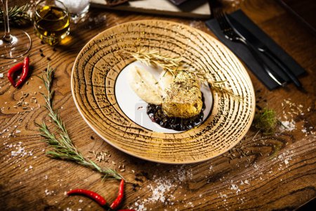 Foto de Filete de lomo negro Angus cubierto con oro de 24 quilates, puré de papas, salsa de vino tinto con bayas, rosmarine - Imagen libre de derechos