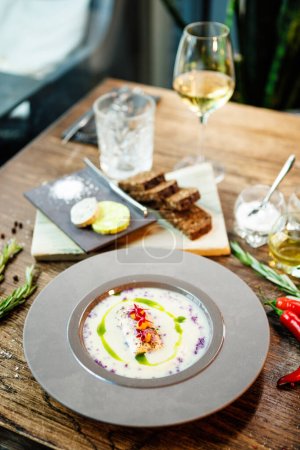 Photo for Jerusalem artichoke-almond cream soup with scallop roll. Leek, almond milk, garlic. Delicious healthy Jewish traditional food closeup served for lunch on a table in modern gourmet cuisine restaurant. - Royalty Free Image
