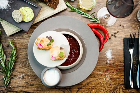 Photo for Beetroot soup Borscht with meat and sourcream in a bowl. Delicious healthy Ukrainian traditional food closeup served for lunch on a table in modern gourmet cuisine restaurant. - Royalty Free Image