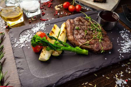 Téléchargez les photos : Black Angus New York steak. Surlonge de bœuf marbré d'Uruguay. Délicieuse cuisine traditionnelle saine servie en gros plan pour le déjeuner dans un restaurant gastronomique moderne. - en image libre de droit