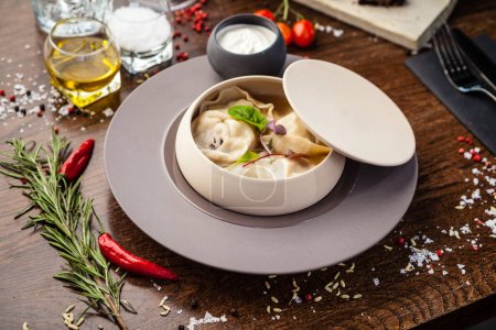Photo for Black Angus beef hand-made dumplings. Cucumber-julienne with chilli-garlic butter and sour cream. Delicious healthy traditional food closeup served for lunch in modern gourmet cuisine restaurant. - Royalty Free Image