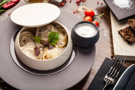 Photo for Black Angus beef hand-made dumplings. Cucumber-julienne with chilli-garlic butter and sour cream. Delicious healthy traditional food closeup served for lunch in modern gourmet cuisine restaurant. - Royalty Free Image