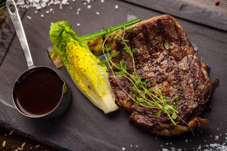 Téléchargez les photos : Steak Angus Entrecote noir. Un steak marbré d'Uruguay. Délicieuse cuisine traditionnelle saine servie en gros plan pour le déjeuner dans un restaurant gastronomique moderne. - en image libre de droit