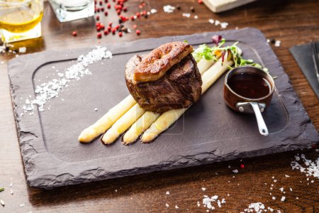 Photo for Tournedos Rossini. Foie gras, Black Angus beef tenderloin, white asparagus, red wine sauce. Delicious healthy traditional food closeup served for lunch in modern gourmet cuisine restaurant. - Royalty Free Image
