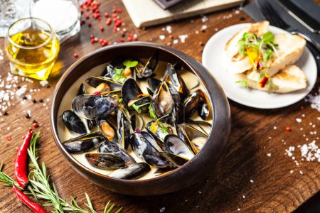 Photo for Blue mussels in cream wine sauce. Delicious healthy Italian traditional food closeup served for lunch in modern gourmet cuisine restaurant. - Royalty Free Image