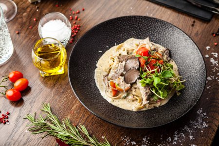 Photo for Black Angus beef tagliatelle pasta with fresh black truffles and parmegano. Delicious healthy traditional food closeup served for lunch in modern gourmet cuisine restaurant. - Royalty Free Image