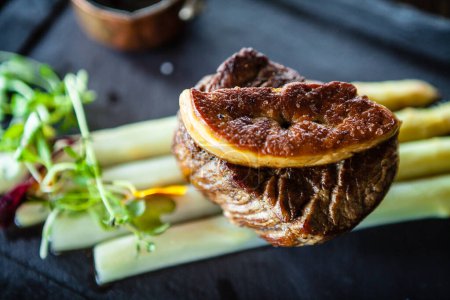 Photo for Tournedos Rossini. Foie gras, Black Angus beef tenderloin, white asparagus, red wine sauce. Delicious healthy traditional food closeup served for lunch in modern gourmet cuisine restaurant. - Royalty Free Image