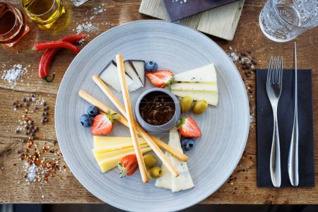 Photo for Cheese platter for two: Goat cheese cream, gorgonzola, camembert, grissini and fig jam. Delicious healthy Italian traditional food closeup served for lunch in modern gourmet cuisine restaurant. - Royalty Free Image