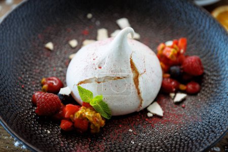 Photo for Pavlova berry cake with passion cream, strawberry, meringue. Delicious sweet dessert food closeup served for lunch in modern gourmet cuisine restaurant. - Royalty Free Image