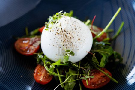 Photo for Burrata with paprika-truffle jam and cherry-cluster tomato salad. Delicious healthy Italian traditional food closeup served for lunch in modern gourmet cuisine restaurant. - Royalty Free Image
