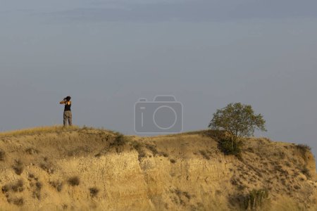 Landscape of young woman tourist in vashlovani national park of Georgia looking at scenery on a hot summer day