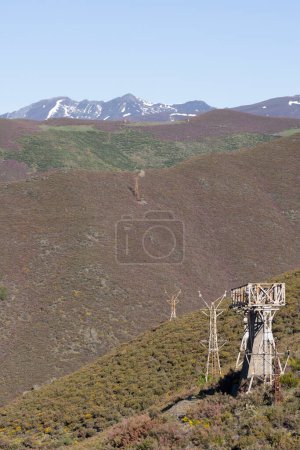 Photo for Abandoned steel structure with towers from industrial coal mining cableway in mountains of Asturias Spain in Tormaleo on a sunny spring day with flowers - Royalty Free Image