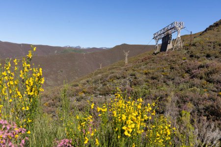 Estructura de acero abandonada con torres del teleférico industrial de minería de carbón en las montañas de Asturias España en Tormaleo en un soleado día de primavera con flores