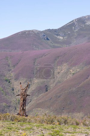 Steel metal tower structure abandoned in the rocky mountains of Asturias Spain on a bright sunny spring day.