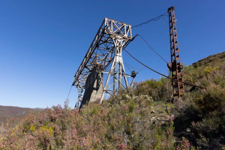 Verlassene industrielle Kohlebergbau Stahlkonstruktion Turm aus Seilbahn mit Seil in Tormaleo Asturias Provinz von Spanien an einem sonnigen Tag.