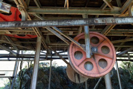 Steel metal wheel in industrial coal mining factory building with beams in Tormaleo Asturias province of Spain.
