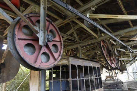 Steel metal wheel in industrial coal mining factory building with beams in Tormaleo Asturias province of Spain.