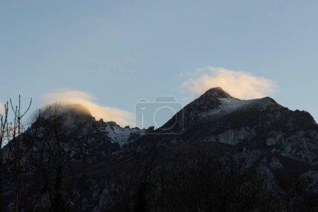 Montaña pico cresta al atardecer con niebla y nubes de niebla en invierno