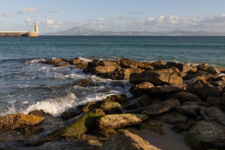 Estatua del Sagrado Corazón de Jesús en Tarifa a orillas del Atlántico y del mar Mediterráneo en un día soleado y luminoso con nubes.