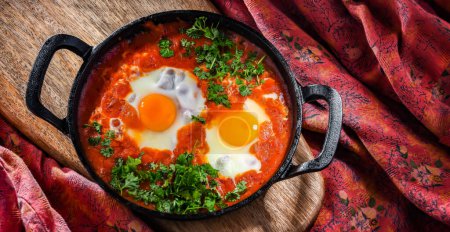Photo for Shakshouka dish in a cast iron pan. - Royalty Free Image