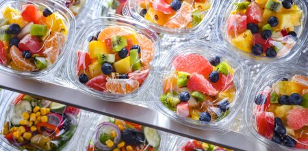 Foto de Plastic boxes with pre-packaged fruit salads, put up for sale in a commercial refrigerator - Imagen libre de derechos