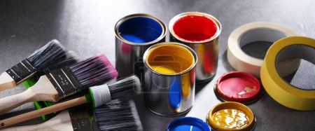 Paint cans and paintbrushes of different size  for home decorating purposes.
