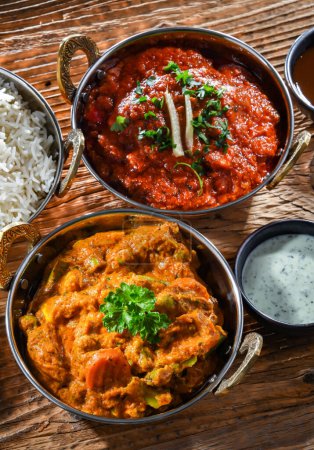 Photo for Hot madras paneer and vegetable masala with basmati rice served in original indian karahi pots. - Royalty Free Image