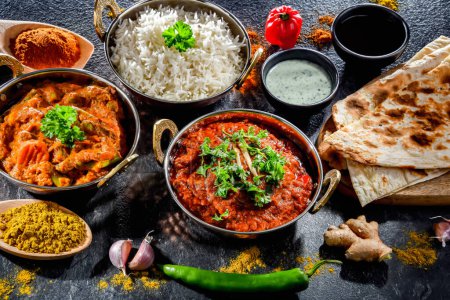 Téléchargez les photos : Hot madras paneer and vegetable masala with basmati rice served in original indian karahi pots. - en image libre de droit
