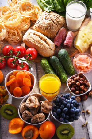 Téléchargez les photos : Composition avec divers produits alimentaires biologiques sur table de cuisine en bois. - en image libre de droit