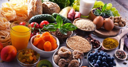 Téléchargez les photos : Composition avec divers produits alimentaires biologiques sur table de cuisine en bois. - en image libre de droit