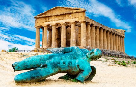 Foto de Templo de Concordia y la estatua de Ícaro caído, en el Valle de los Templos, Agrigento, Sicilia, Italia - Imagen libre de derechos