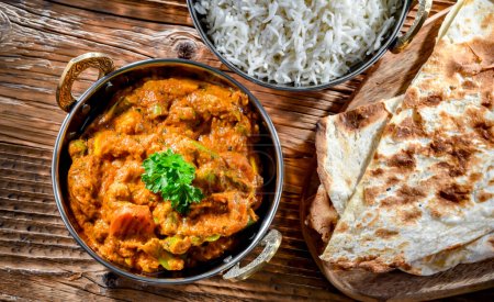Photo for Hot madras paneer and vegetable masala with basmati rice served in original indian karahi pots. - Royalty Free Image