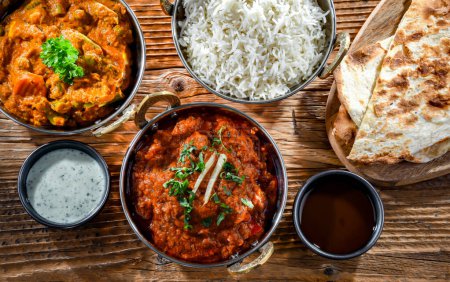 Téléchargez les photos : Hot madras paneer and vegetable masala with basmati rice served in original indian karahi pots. - en image libre de droit