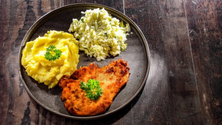 Photo for Chicken cutlet coated with breadcrumbs served with potatoes and cabbage - Royalty Free Image