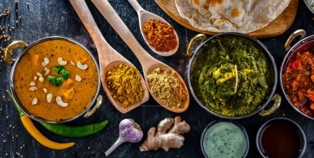 Téléchargez les photos : Composition avec plats indiens : madras paneer, palak paneer et shahi paneer au riz basmati servi dans des pots karahi indiens originaux - en image libre de droit