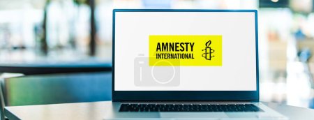 Foto de POZNAN, POL - 6 ENE 2021: Computadora portátil con el logotipo de Amnistía Internacional, una organización no gubernamental con sede en Londres, Inglaterra, centrada en los derechos humanos - Imagen libre de derechos