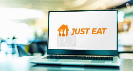 Téléchargez les photos : POZNAN, POL - NOV 22, 2022 : Ordinateur portable affichant le logo de Just Eat, une commande alimentaire en ligne et marque de livraison de Just Eat Takeaway.com basée aux Pays-Bas - en image libre de droit